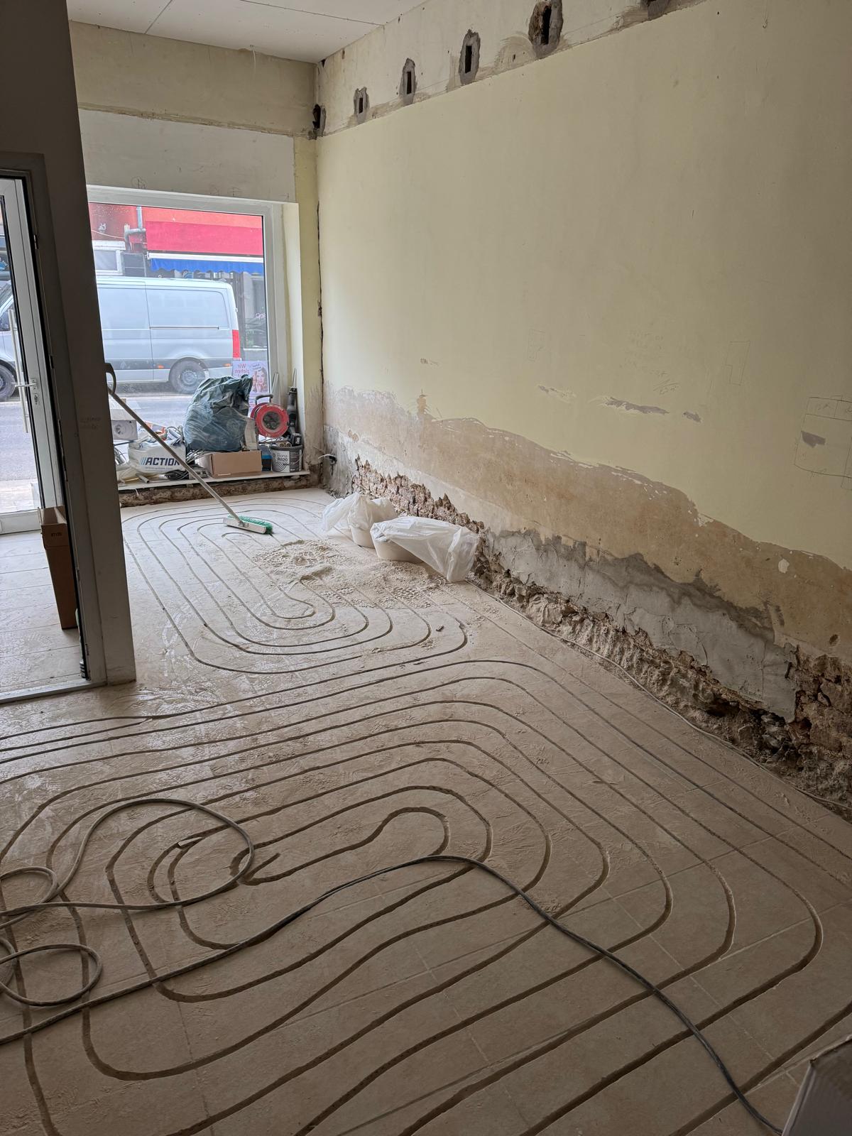 Verlegung der Fußbodenheizung mit sichtbaren Heizschläuchen.