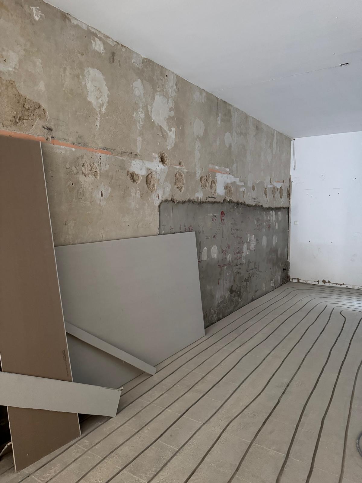 Estrich frisch verlegt über der Fußbodenheizung mit deutlich sichtbaren Strukturen.